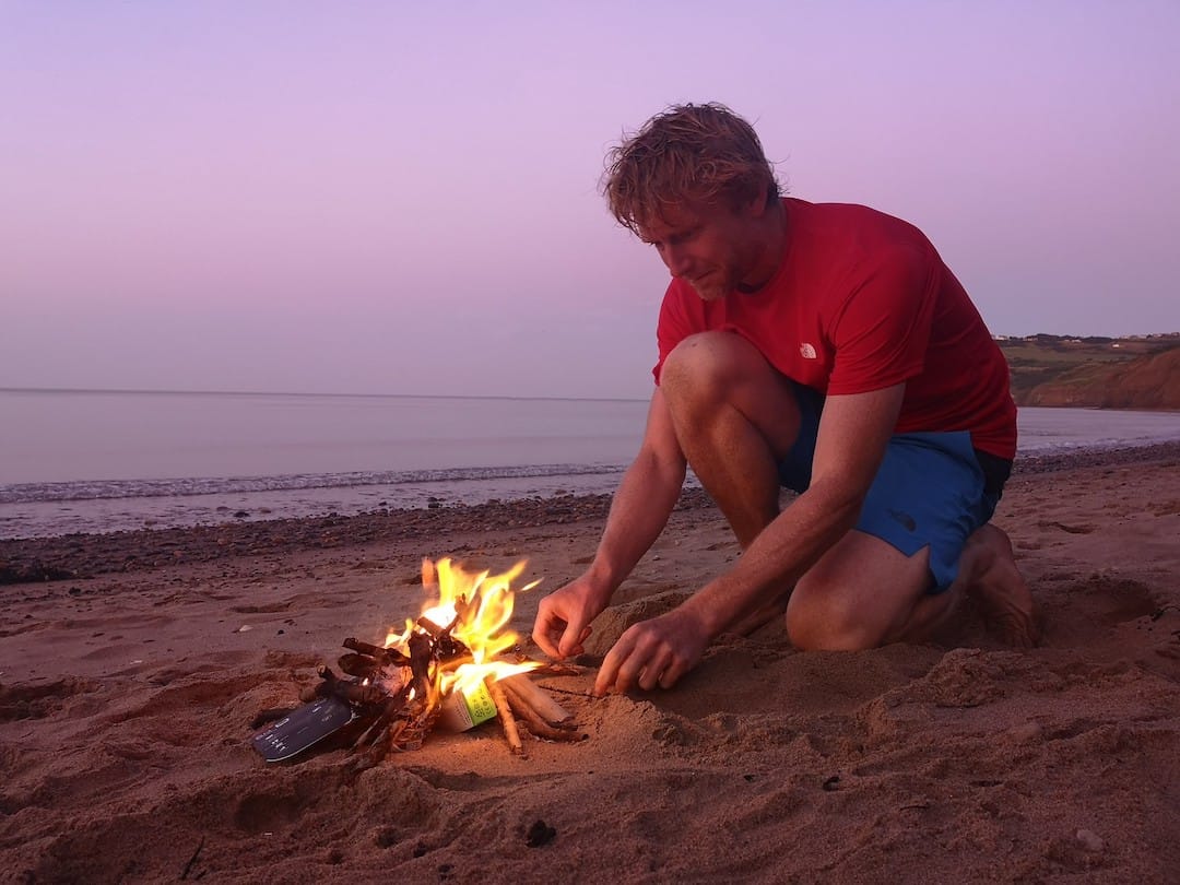 Picture shows Alastair lighting a fire on the beach