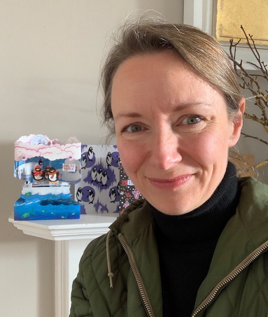 Maggie in front of her mantlepiece which has Christmas cards on it