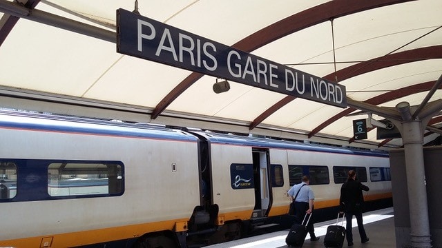 Picture shows a parked train on a platform with the sign saying "Paris Gare Du Nord". 