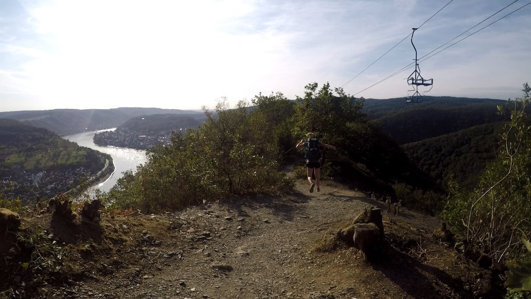 Picture shows Rosie running down a hillside near a chairlift. There are many shrubs around and the sun is shining. 